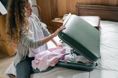 A woman unpacking a suitcase.