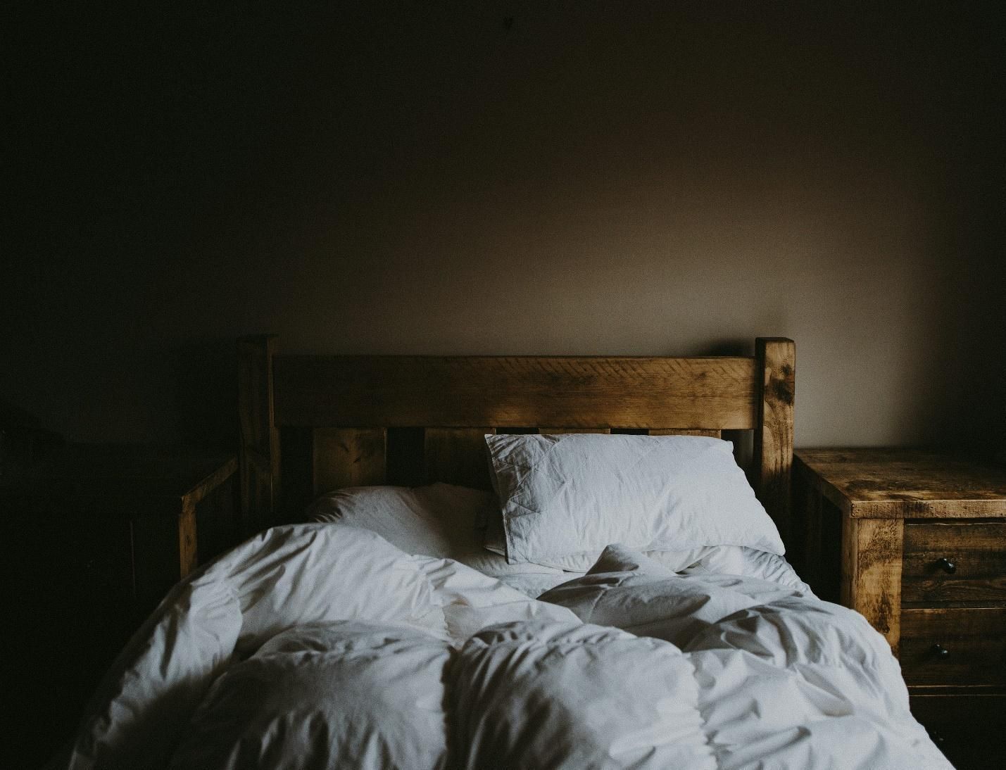 A wooden bed and nightstand.