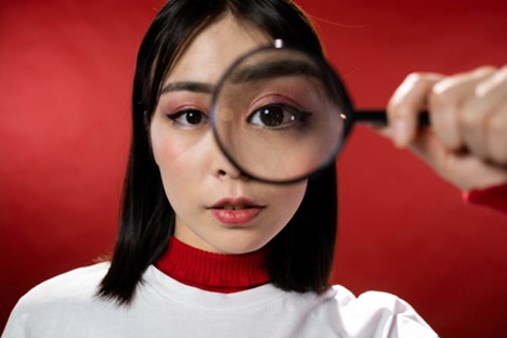 A woman looking through a magnifying glass.