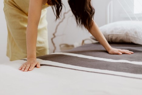 A woman making a bed.